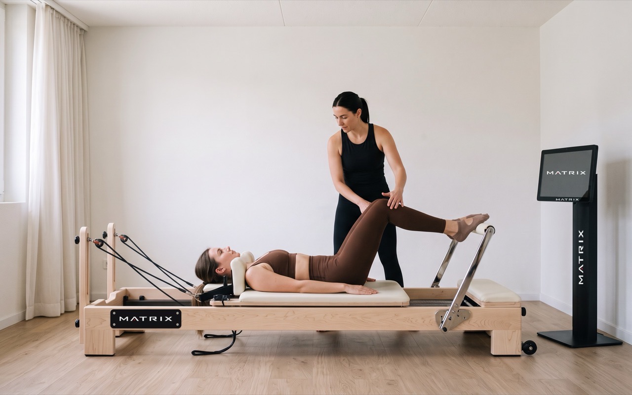 Personal Training am Reformer: Trainerin führt das Bein